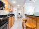 Modern kitchen with wood cabinets, granite countertops, and breakfast bar at 51 Island Way # 1107, Clearwater Beach, FL 33767
