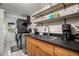 Modern kitchen with stacked washer and dryer, wood cabinets, and dark countertops at 4530 Flounder Dr, Hernando Beach, FL 34607