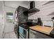 Modern kitchen with stacked washer and dryer, wood cabinets, and dark countertops at 4530 Flounder Dr, Hernando Beach, FL 34607