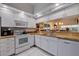 Bright kitchen with white cabinets, granite counters, and appliances at 6499 99Th N Way # 18B, St Petersburg, FL 33708