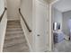 Indoor staircase with carpeted steps and dark wood railing at 5608 Madrigal Way, Apollo Beach, FL 33572