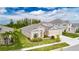 Tan house with a three-car garage and lush landscaping at 5608 Madrigal Way, Apollo Beach, FL 33572