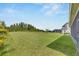 Large backyard with grassy area and trees at 5608 Madrigal Way, Apollo Beach, FL 33572