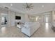 Bright and airy living room features a sectional sofa, hardwood floors, and a large TV at 5608 Madrigal Way, Apollo Beach, FL 33572