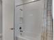 Clean bathroom with white tile, shower/tub combo, and patterned shower curtain at 5608 Madrigal Way, Apollo Beach, FL 33572