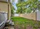 Grass backyard with a wooden fence and steps leading to a patio at 406 S Bayview Blvd # 1, Oldsmar, FL 34677