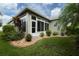 House exterior featuring a sunroom and well-manicured landscaping at 15818 Cobble Mill Dr, Wimauma, FL 33598