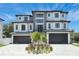 Modern luxury home with gray and white facade, three-car garage at 6012 Kipps Colony E Dr, Gulfport, FL 33707