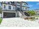 Contemporary home's exterior features a stone facade, modern garage doors, and landscaping at 6012 Kipps Colony E Dr, Gulfport, FL 33707