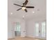 Bright bedroom with hardwood floors, ceiling fan, and French doors leading to a balcony at 6012 Kipps Colony E Dr, Gulfport, FL 33707