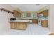 U-shaped kitchen with wood cabinets and tiled floor at 5142 Silver Bell Dr, Port Charlotte, FL 33948