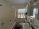 Bright bathroom featuring a tub/shower, white fixtures, and a window with natural light at 15536 Bristol E Cir, Clearwater, FL 33764