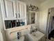 Neat bathroom with white vanity, subway tile, and organized shelving for storage at 15536 Bristol E Cir, Clearwater, FL 33764