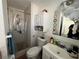Cozy bathroom featuring a tiled shower, white vanity, and mirrored cabinet for storage at 15536 Bristol E Cir, Clearwater, FL 33764
