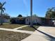 Inviting single-story home with palm trees, walkway, and covered carport providing shelter and curb appeal at 15536 Bristol E Cir, Clearwater, FL 33764