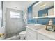 Updated bathroom with white vanity, marble shower, and blue accents at 1627 Dander Dr, Holiday, FL 34690