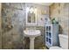 Bathroom with pedestal sink, stone tile shower, and small cabinet at 1627 Dander Dr, Holiday, FL 34690