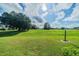 Landscaped backyard with green grass and mature trees at 739 Winterbrooke Way, Sun City Center, FL 33573
