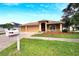 Tan three-car garage home with a red door and nicely landscaped yard at 12739 Standbridge Dr, Riverview, FL 33579