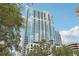High-rise building with lush green trees in the foreground at 777 N Ashley Dr # 1606, Tampa, FL 33602