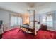Spacious main bedroom with a post bed and red carpet at 739 Winterbrooke Way, Sun City Center, FL 33573