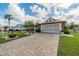 Single-Gathering home with paver driveway, landscaping, and a two-car garage at 739 Winterbrooke Way, Sun City Center, FL 33573