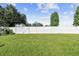 Large backyard with a grassy area and a white fence at 35744 Jenny Lynne Cir, Zephyrhills, FL 33541