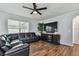 Living room with hardwood floors, large TV, and comfy seating at 35744 Jenny Lynne Cir, Zephyrhills, FL 33541