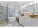 Spa-like bathroom featuring a soaking tub, double sinks, and marble tile at 9733 Long Meadow Dr, Tampa, FL 33615