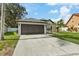 One-story house with a two-car garage and landscaped lawn at 9733 Long Meadow Dr, Tampa, FL 33615