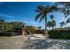Charming single-story home features a brick exterior, a spacious driveway, and lush landscaping with palm trees at 11921 Lagoon Ln, Treasure Island, FL 33706