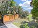Private backyard with raised garden beds, a custom fence, and a view of the surrounding greenery at 1385 Embassy Dr, Clearwater, FL 33764