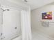 Light-filled bathroom with a shower-tub combo and decorative art at 1385 Embassy Dr, Clearwater, FL 33764