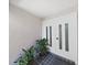 Elegant double front door with decorative glass panels, complemented by potted plants and tile flooring at 1385 Embassy Dr, Clearwater, FL 33764