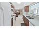 Kitchen featuring wood cabinets and a view into the dining area and the lanai at 1385 Embassy Dr, Clearwater, FL 33764