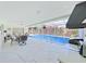 Spacious screened-in pool area with a dining set, grill, and view of the serene pool and lush yard at 1385 Embassy Dr, Clearwater, FL 33764
