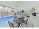 Charming screened-in pool with a dining area, providing a serene view of the lush backyard at 1385 Embassy Dr, Clearwater, FL 33764