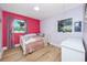Bright bedroom with wood floors, colorful decor, and a large window with natural light at 6619 Livingston N Ave, St Petersburg, FL 33702