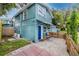 Exterior view featuring a light blue house with a cozy patio area and a fenced yard at 6619 Livingston N Ave, St Petersburg, FL 33702
