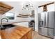 Bright kitchen featuring butcher block countertops, white cabinetry, stainless steel appliances, and modern lighting at 6619 Livingston N Ave, St Petersburg, FL 33702