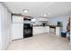 Bright kitchen with white cabinets, black appliances, and a stainless steel dishwasher at 6619 Livingston N Ave, St Petersburg, FL 33702