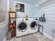 Well-organized laundry room with updated washer and dryer, storage shelves, and tile flooring at 6619 Livingston N Ave, St Petersburg, FL 33702