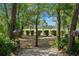 Picturesque backyard with a stone path, mature trees, and a distant view of the golf course at 9 Pelican Pl, Belleair, FL 33756