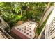 A secluded backyard view from patio provides a tranquil retreat, featuring lush greenery and a stone pathway at 9 Pelican Pl, Belleair, FL 33756
