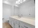 Well lit bathroom featuring a double sink vanity, large mirror, and neutral tile flooring at 9 Pelican Pl, Belleair, FL 33756