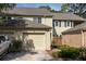 Charming townhouse featuring a light beige exterior, brick driveway, and a single car garage at 9 Pelican Pl, Belleair, FL 33756