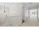Upstairs hallway with neutral carpet and access to bedrooms at 9 Pelican Pl, Belleair, FL 33756