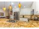 Spacious kitchen with granite countertops, stainless appliances, and stylish lighting at 9 Pelican Pl, Belleair, FL 33756