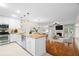 Open-concept kitchen featuring white cabinets, stainless appliances, and granite countertops at 9 Pelican Pl, Belleair, FL 33756