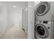 Laundry room features a stacked washer and dryer set and access to the upper level of the home at 9 Pelican Pl, Belleair, FL 33756